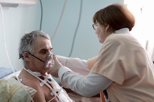 Nurse adjusting oxygen mask on older patient