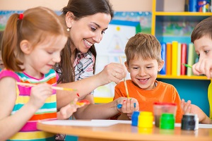 Children drawing with staff member during day care