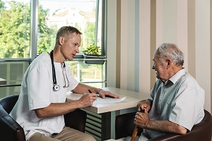 A doctor visits an elderly resident of a nursing home