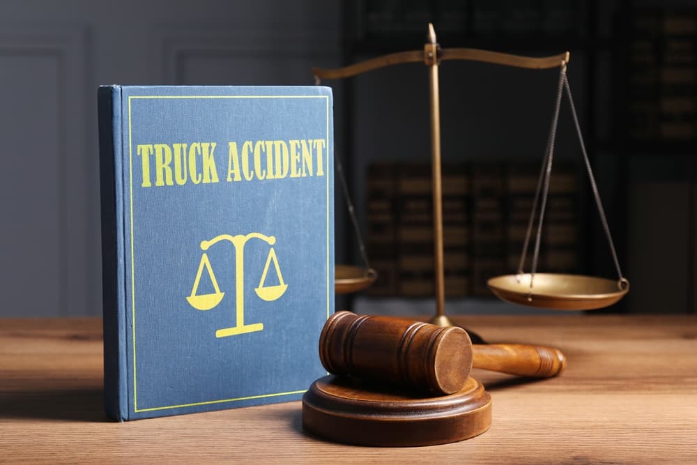 Truck Accident law book, judge's gavel and scales on wooden table