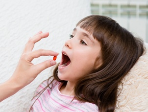 child in bed being given medication