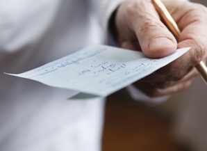 doctor holding handwritten prescription and pencil