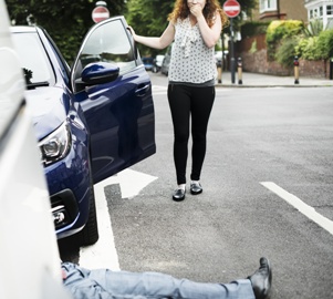 woman getting out of car after hitting pedestrian