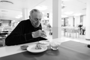 elderly man eating in a nursing home dining room