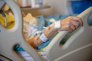 elderly woman in hospital bed nursing home with IV tubes