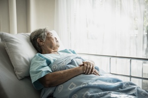 elderly woman in nursing home bed at risk for bedsores