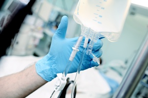 healthcare worker adjusting IV fluids