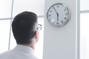 man looking at wall clock