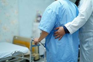 medical assistant helping elderly patient with walker