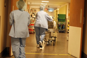 nurse pushing hospital gurney with patient