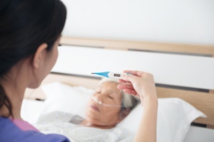nurse taking nursing home patient's temperature
