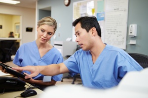 nursing discussing shift change at nurses station in hospital