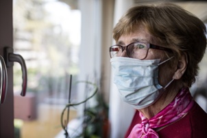 older woman wearing mask in nursing home