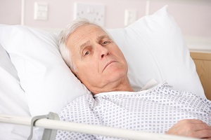 Older man is uncomfortable in a hospital bed