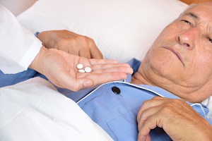 Doctor gives medication to elderly man in bed