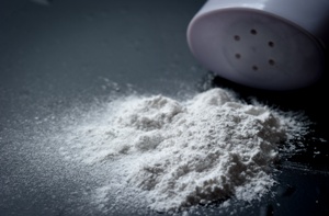 talcum powder and bottle on black background