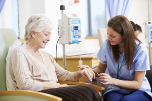 woman getting chemotherapy with nurse by her side